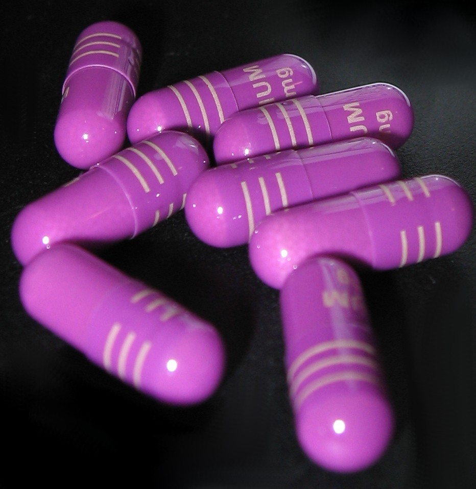 Eight Nexium (esomeprazole magnesium) pills, 40 mg, against a black background.